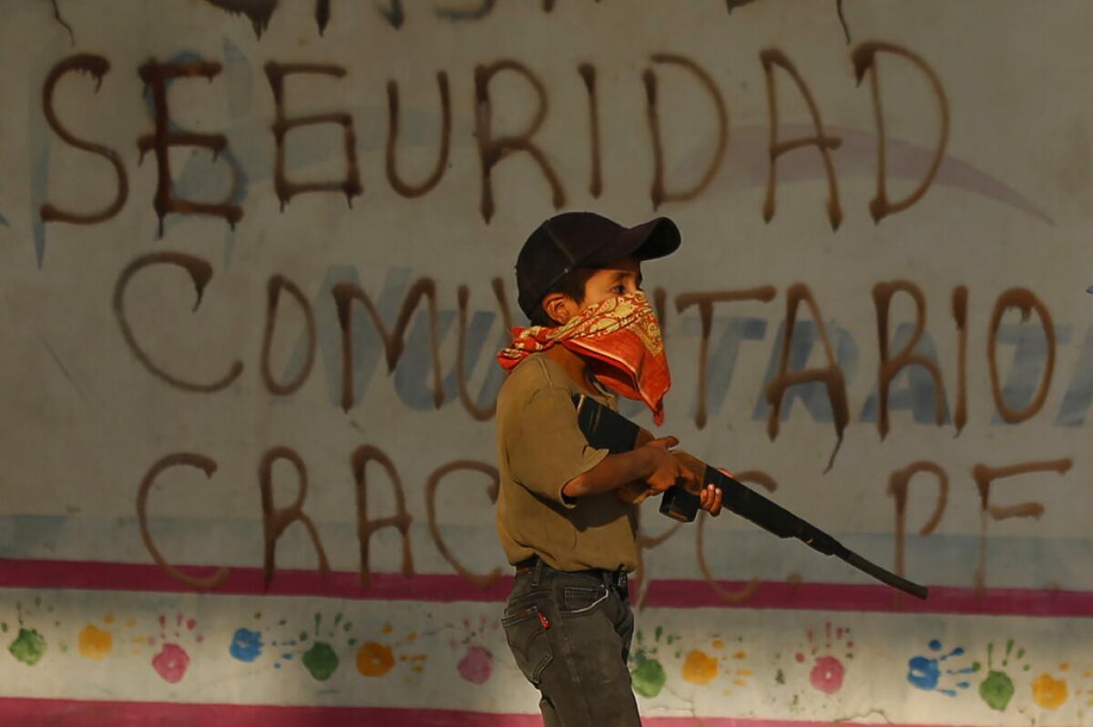 Un niño practica con un rifle de madera falso 