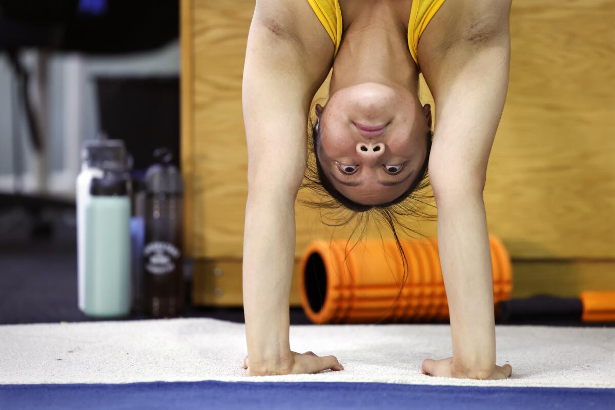 加州大学洛杉矶分校青少年体操运动员艾玛·马拉布约 (Emma Malabuyo) 在棕熊队校园的训练中进行倒立。