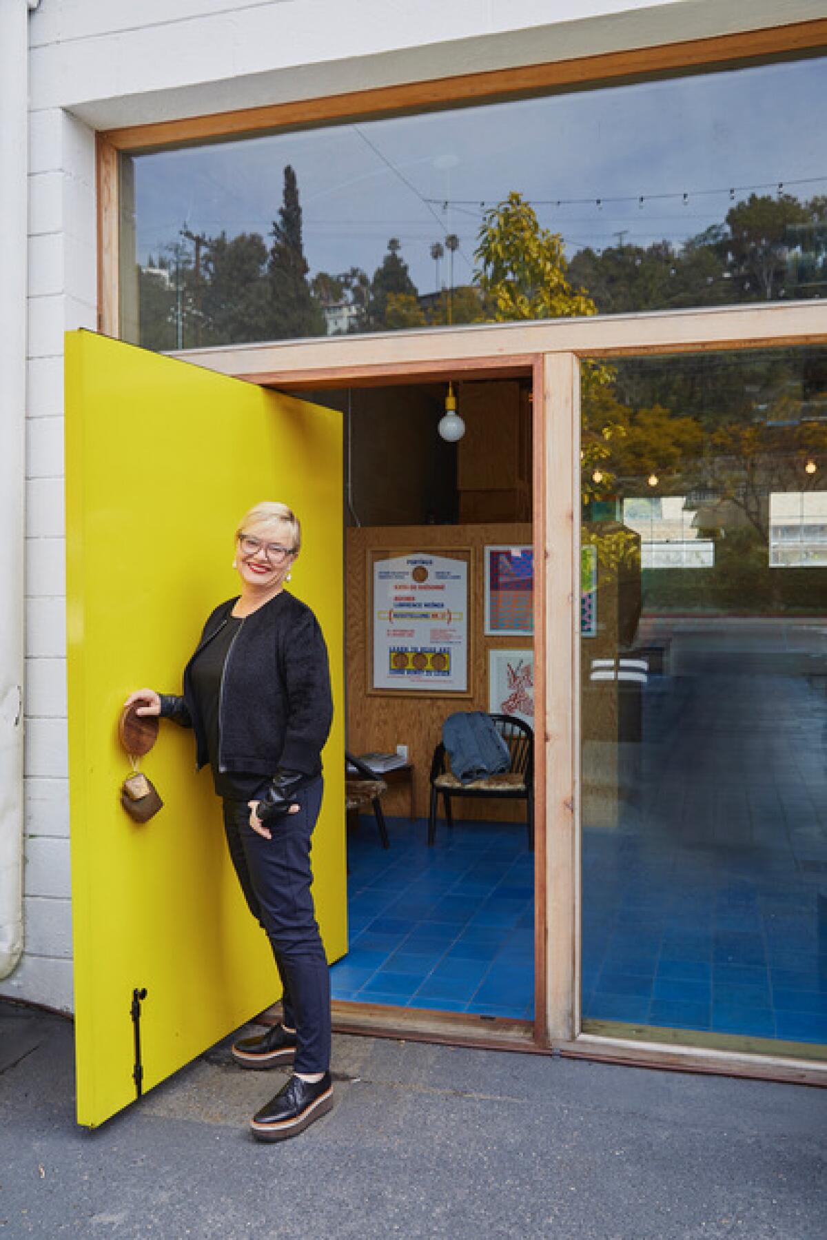 Silver Lake architect Barbara Bestor stands next to an open yellow door.