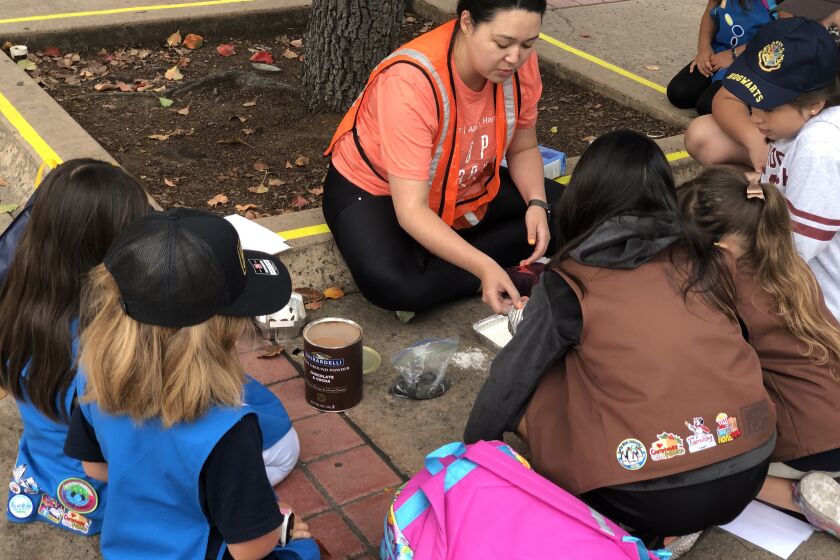 A Booz Allen employee leads a STEM activity with local San Diego Girl Scouts.