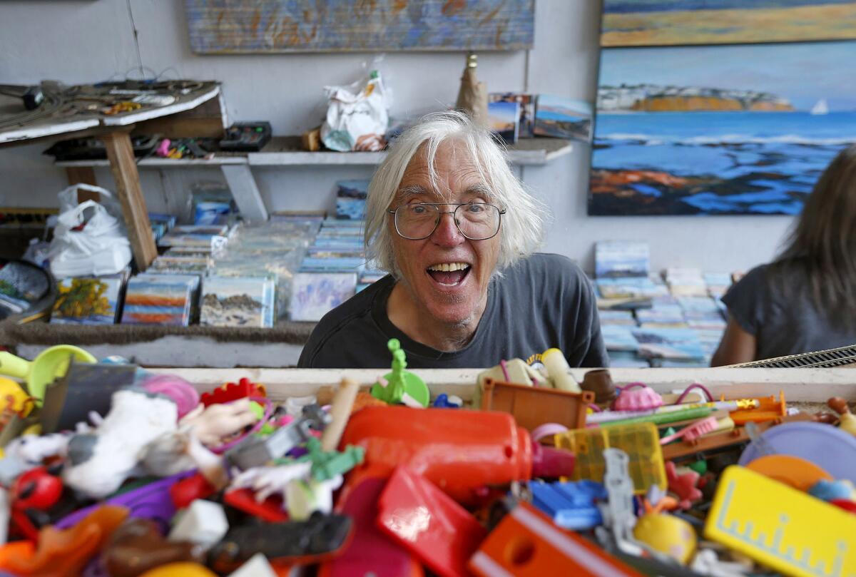Longtime exhibitor and local Doug Miller smiles at guests over his table of toys at the Sawdust Art Festival on Tuesday.