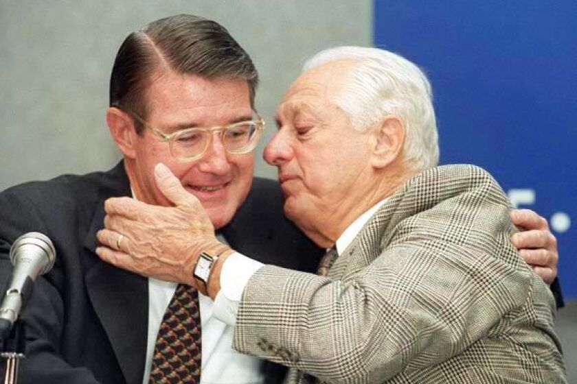 Peter O'Malley hugs Tom Lasorda after the manager's retirement announcement in 1996.