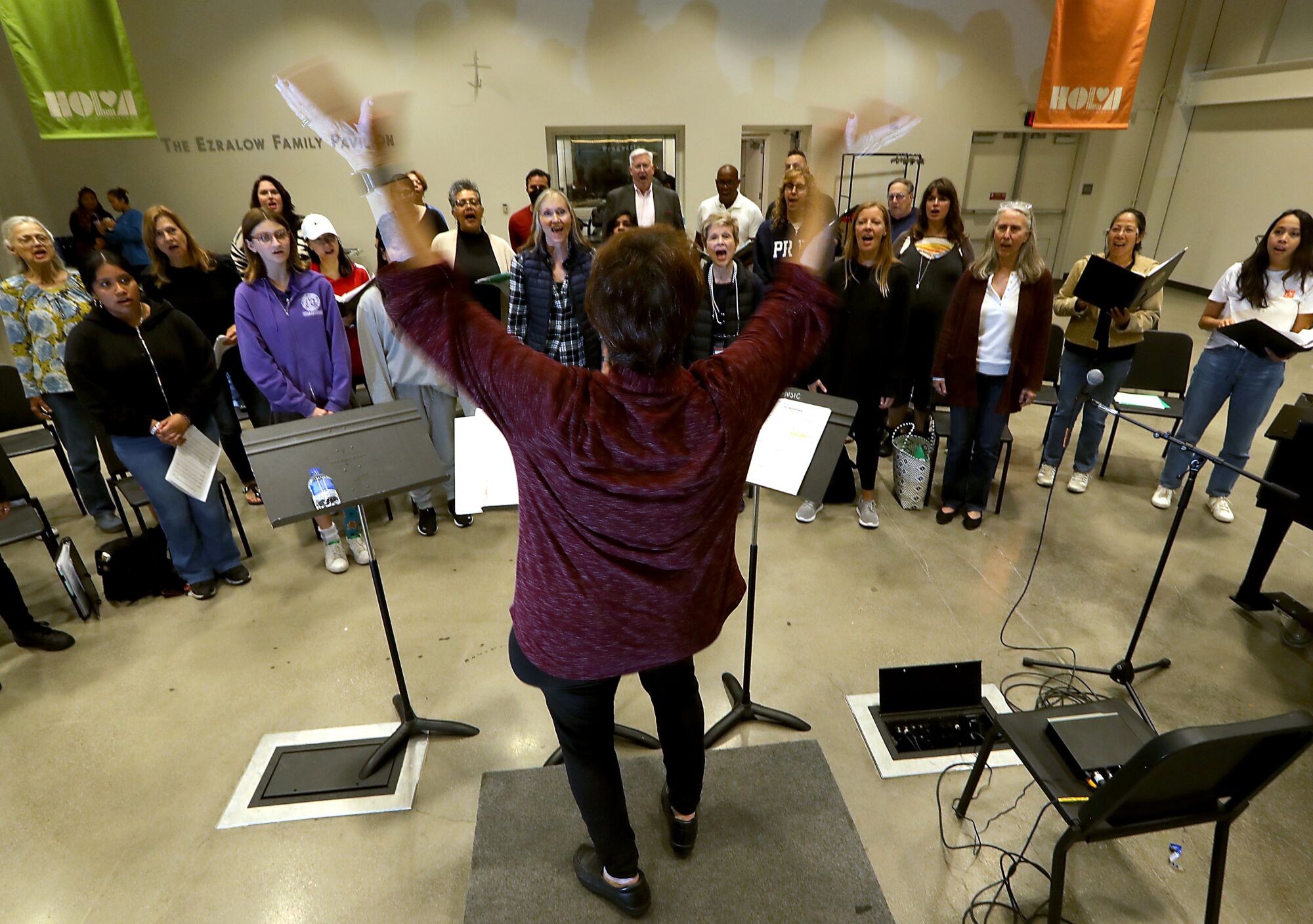 Lydia Saxton conducts the Heart of LA Choir during rehearsals at Lafayette Park in Los Angeles.