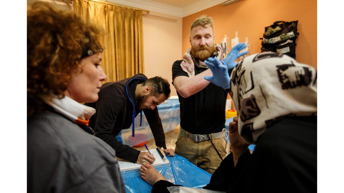 Dr. Cornelius "Woody" Peeples, tries to speak his concerns in Arabic to a woman showing symptoms of diabetes at a field clinic operated by medics from the Iraqi Emergency Response Division and New York City Medics near the front lines in Mosul.