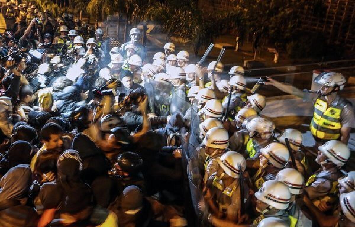 Demonstrators clash with the riot police in front of the legislative assembly in Sao Paulo as they demand the resignation of officials over the disappearance of construction worker Amarildo de Souza.
