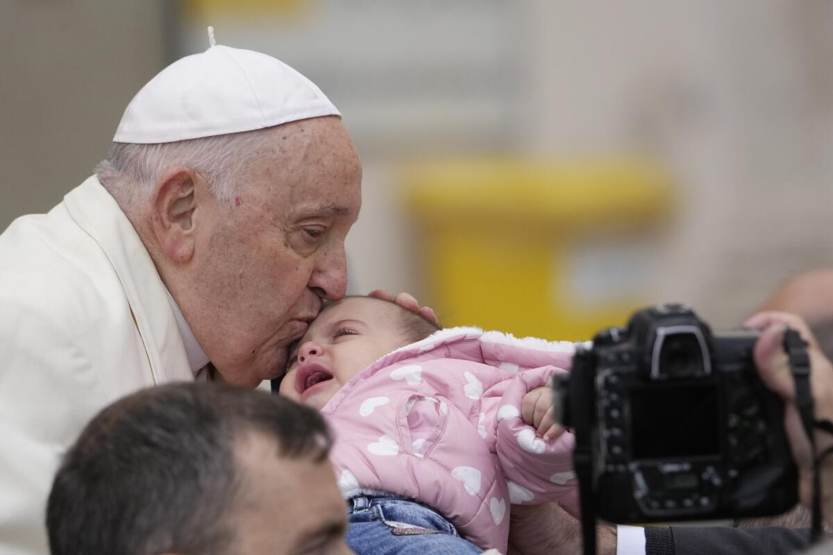 Pope Francis kissing a baby