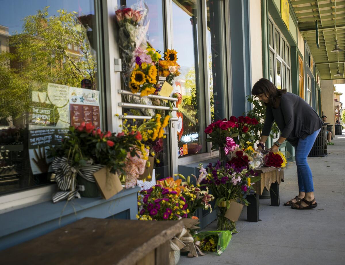 Una mujer deposita un ramo de flores en un altar improvisado para recordar a la copropietaria de una floristería, Jillian Johnson, en Lafayette. Johnson es una de las víctimas de la balacera mortal. (Paul Kieu/The Daily Advertiser via AP)
