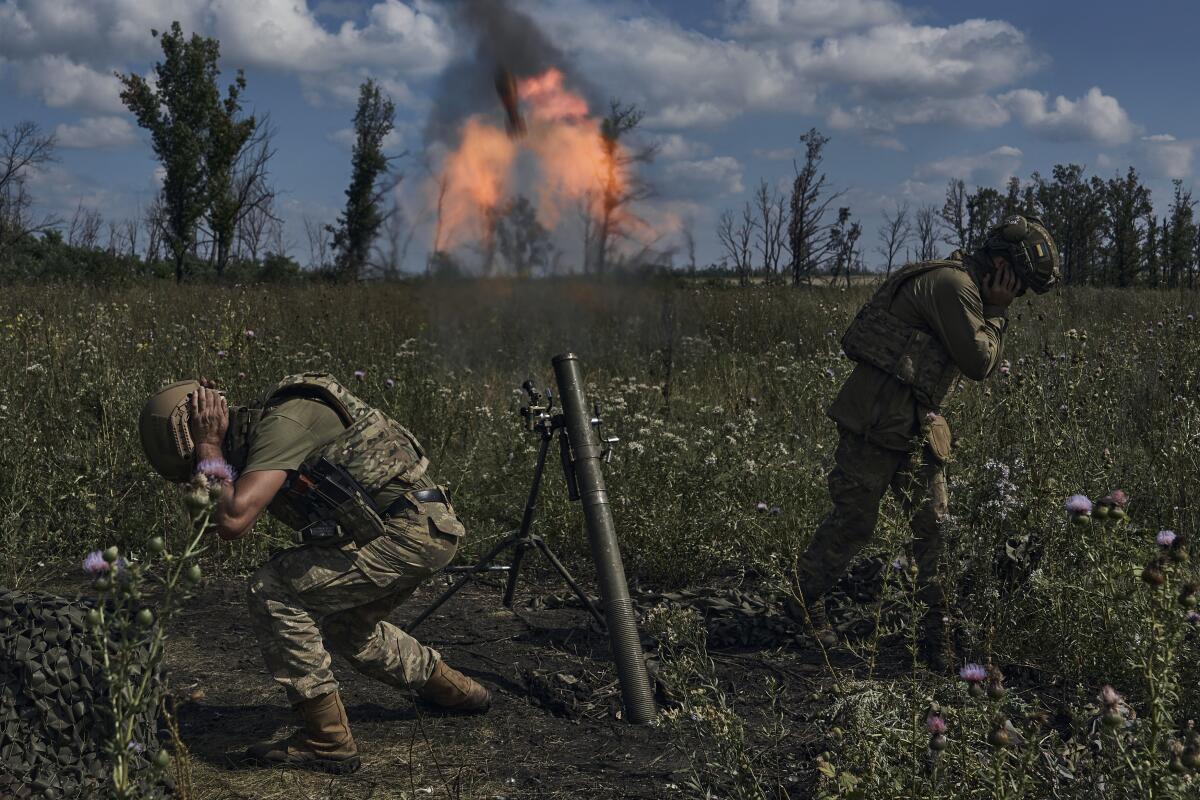Soldiers duck after firing a mortar.