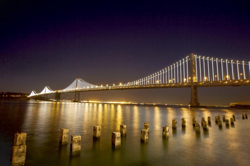 The Bay Lights at Embarcadero, a nearly two-mile-long ever-changing lighted stretch of the western section of the Bay Bridge designed by Leo Villareal, is reminiscent of four gigantic snow-covered holiday trees. (courtesy of San Francisco Travel Association)