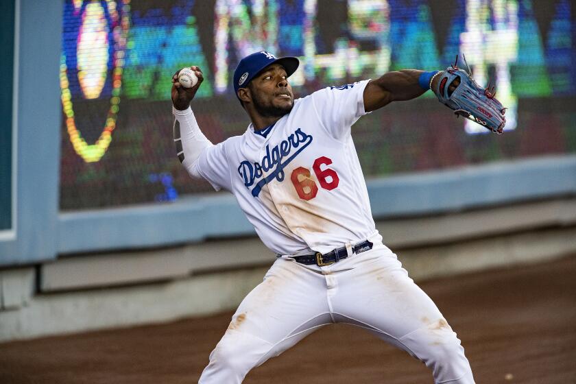 LOS ANGELES, CA - OCTOBER 17, 2018: Los Angeles Dodgers right fielder Yasiel Puig (66) throws the ball in from the warning track on a double hit by Milwaukee Brewers Curtis Granderson in the eighth inning during Game 5 off the NLCS at Dodger Stadium on October 17, 2018 in Los Angeles, California.(Gina Ferazzi/Los AngelesTimes)