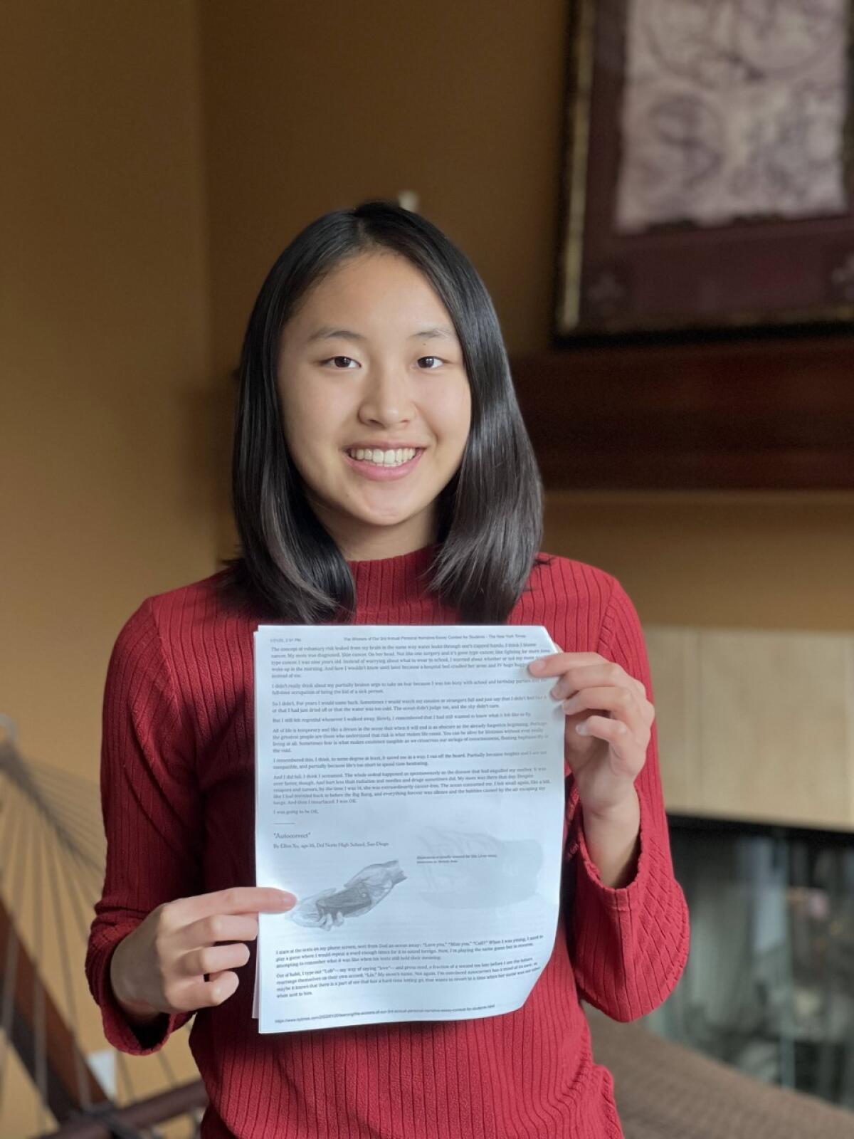 Ellen Xu, 16, holds a copy of her essay, which appeared in the New York Times.