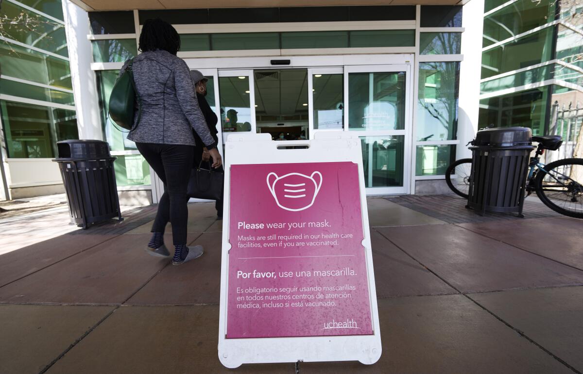 A sign advises visitors to don face coverings at a hospital in Aurora, Colo. 