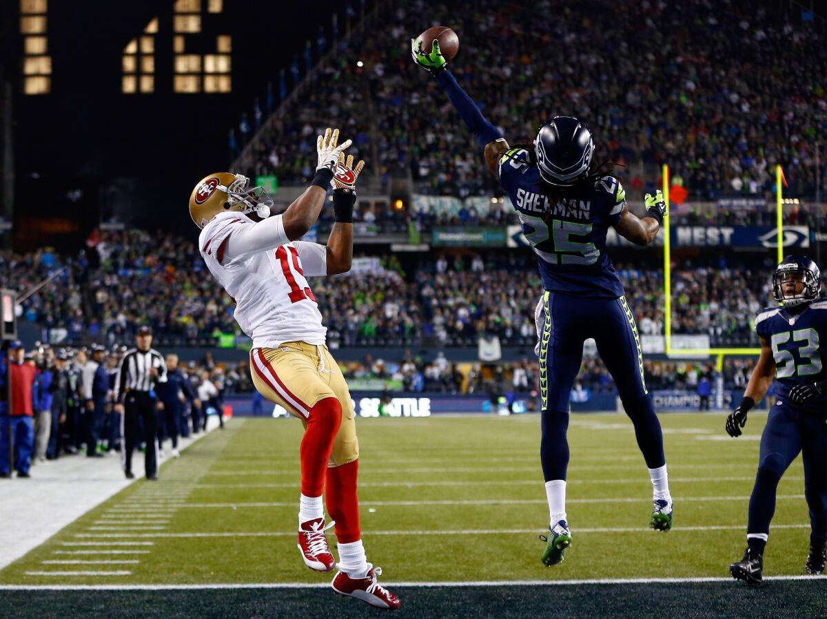 Cornerback Richard Sherman of the Seattle Seahawks tips the ball in the end zone, allowing teammate Malcolm Smith to intercept it and clinch the victory.