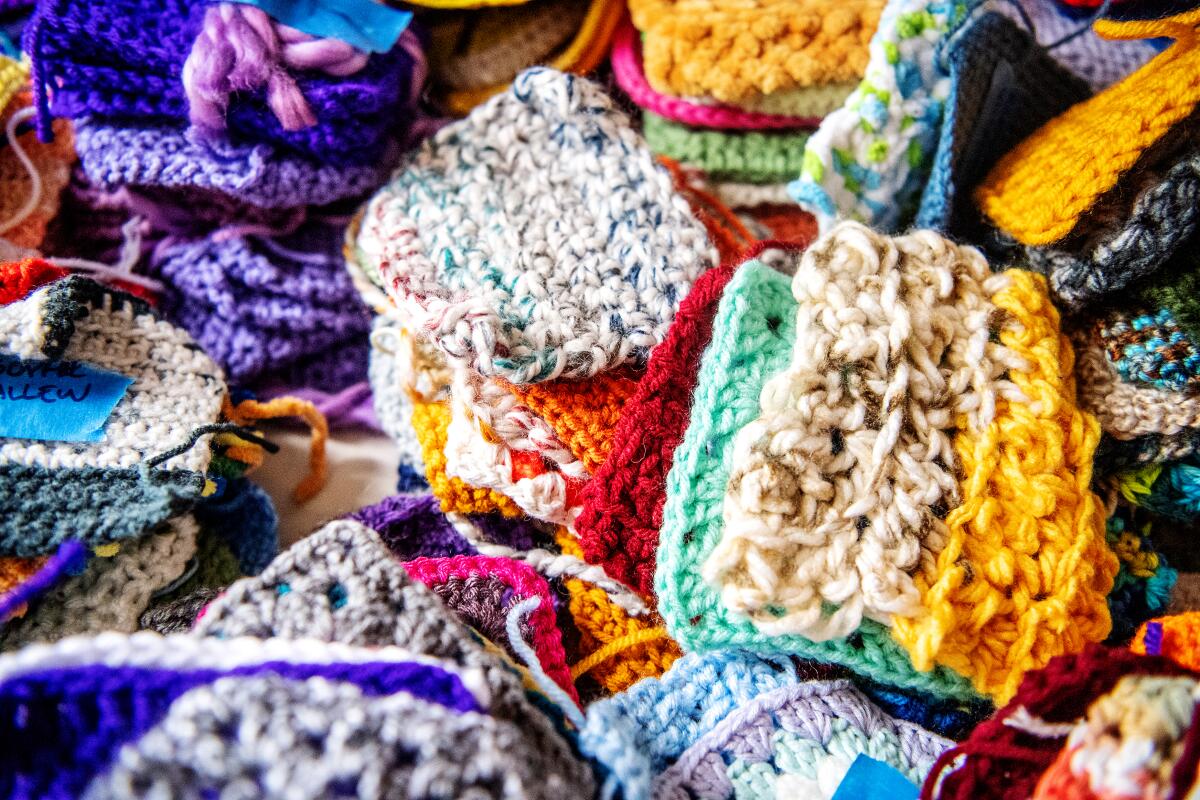 A photo of a colorful pile of hand-knitted squares sent to TikTok sensation Liv Huffman