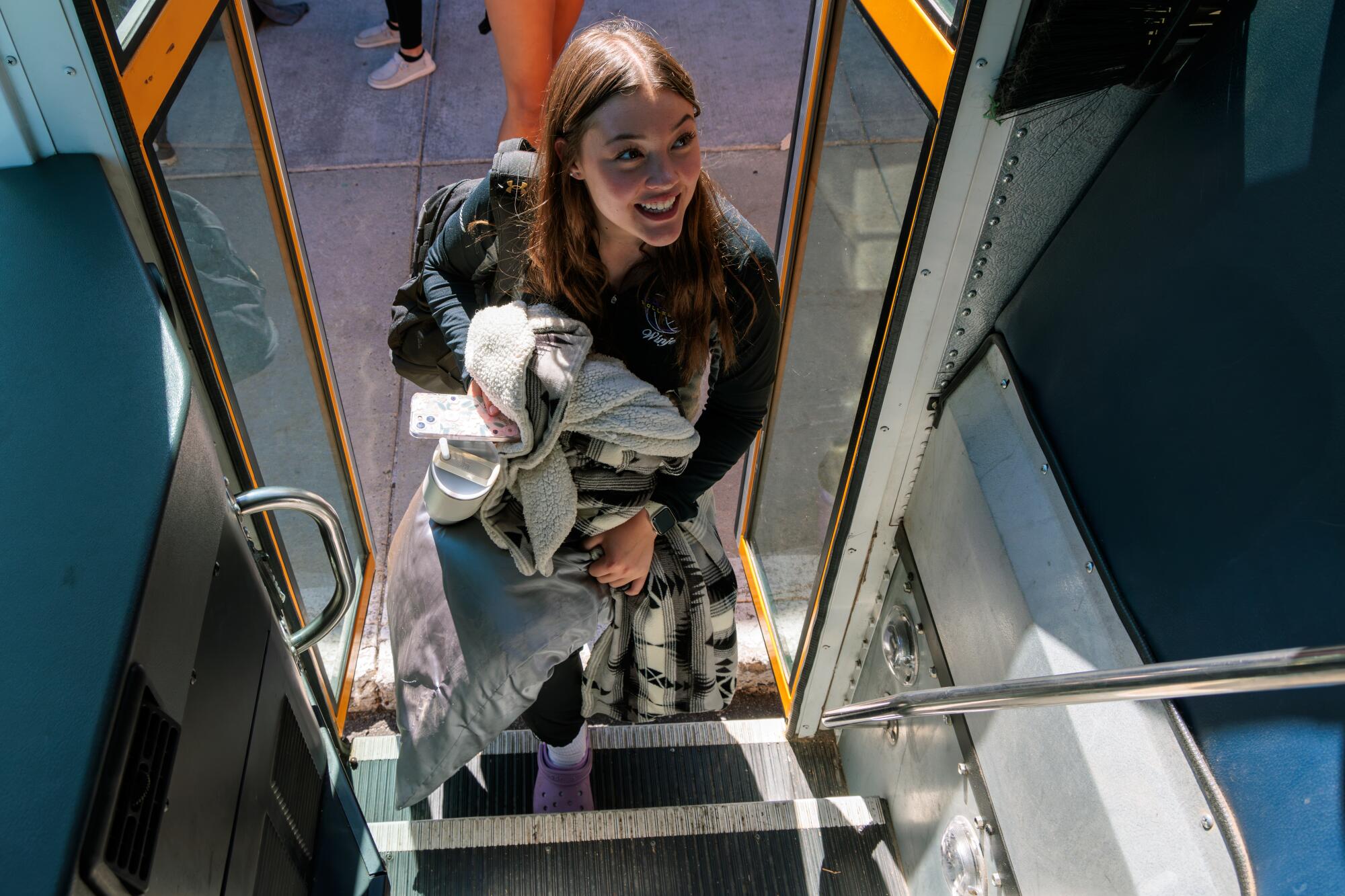 A girl, seen from the driver's point of view, boards a bus.