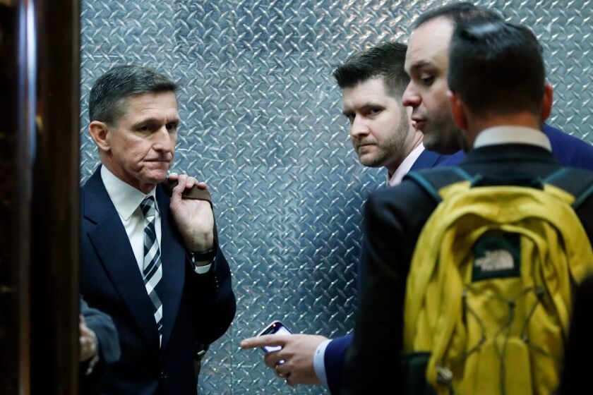 FILE- In this Nov. 17, 2016, file photo, retired Lt. Gen Michael Flynn, left, his son Michael G. Flynn, second from left, and Boris Epshteyn, a spokesman for President-elect Donald Trump, third from left, board an elevator at Trump Tower in New York. Michael G. Flynn tweeted about the false idea that prompted a shooting at a Washington, D.C., pizza parlor. Vice President-elect Mike Pence acknowledged Tuesday, Dec. 6, that the younger Flynn was helping his father with scheduling and administrative items during the presidential transition but told CNN "that's no longer the case." (AP Photo/Carolyn Kaster, File)