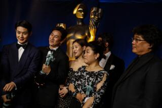 Lee Sun Kyun and Bong Joon Ho are among a group smiling and posing with SAG award trophies in hand