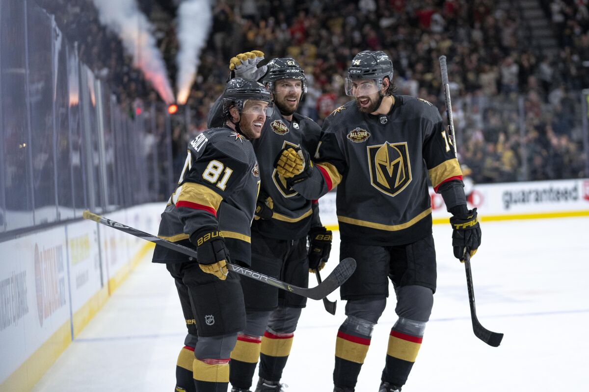 Las Vegas Golden Knights center Jonathan Marchessault (81) celebrates his goal with Shea Theodore (27) and Nicolas Hague (14) during the second period of an NHL hockey game against the Minnesota Wild on Thursday, Nov. 11, 2021, in Las Vegas. (AP Photo/Eric Jamison)