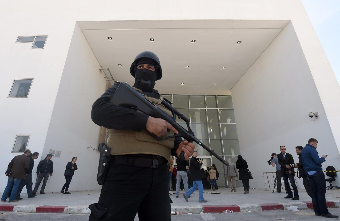 A member of the Tunisian security forces stands guard as journalists gather at the National Bardo Museum in Tunis on March 19, in the aftermath of an attack on foreign tourists.