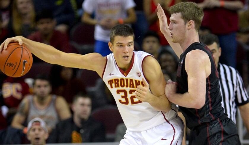 USC forward Nikola Jovanovic (32) gathers a pass as he works in the post against Stanford center Grant Verhoeven in the first half Sunday.