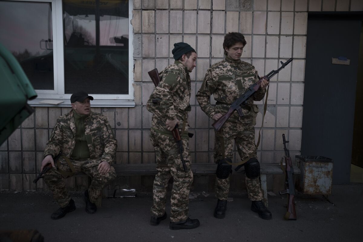 Volunteers with Ukraine's military holding their weapons