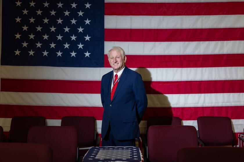 Redding, CA - February 25: Shasta County Clerk & Registrar of Voters Clint Curtis poses for a portrait in front of a large American flag in his new election observer area at the Market Street elections office on Wednesday, Feb. 25, 2026 in Redding, CA. (Jason Armond / Los Angeles Times)