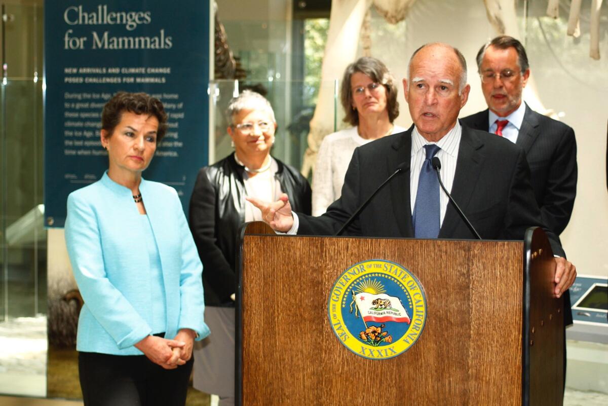 Gov. Jerry Brown speaks as Christiana Figueres, left, executive secretary of the U.N. Framework Convention on Climate Change, listens during a June news conference at the Natural History Museum of Los Angeles County.