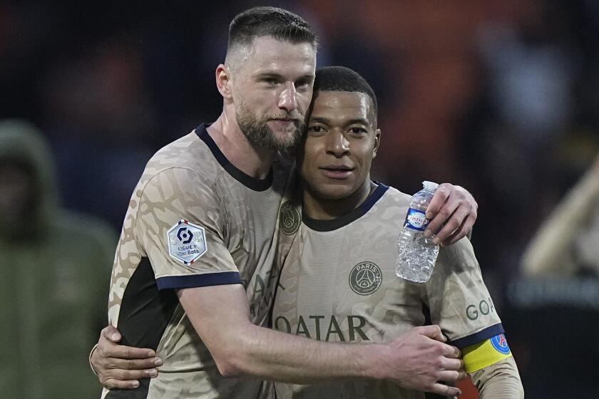 PSG's Milan Skriniar, left, hugs Kylian Mbappe after winning the French League One soccer match between Lorient and Paris Saint-Germain at the Moustoir stadium in Lorient, Brittany, western France, Wednesday, April 24, 2024. (AP Photo/Michel Euler)