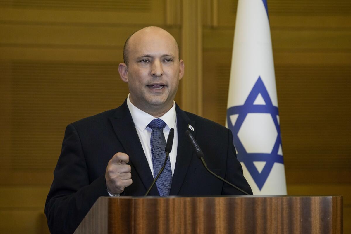 Israeli Prime Minister Naftali Bennett speaks at a lectern.