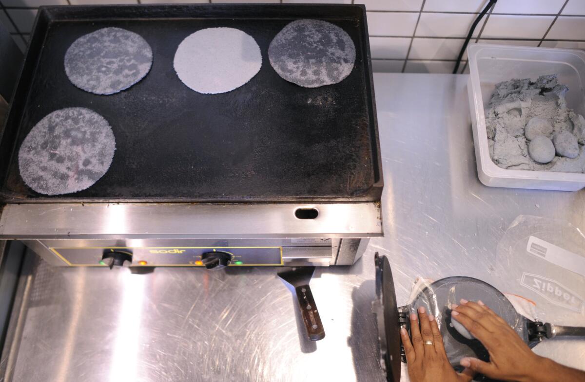 Tortillas are pressed by hand to order and cooked on a grill at Taco Maria.