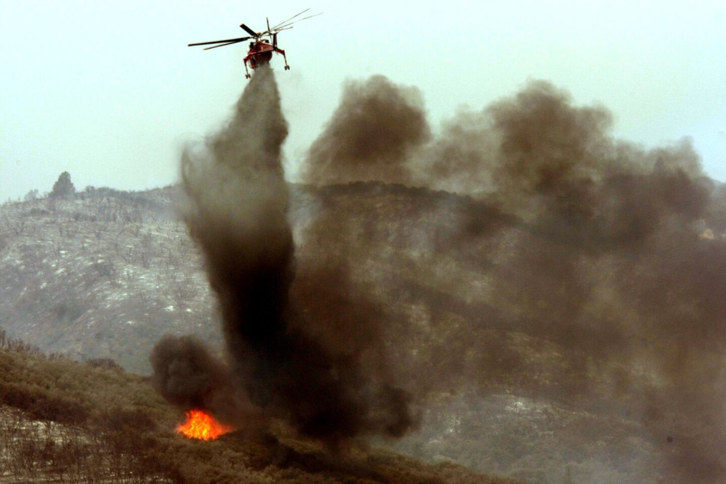 A helicopter puts out a hot spot on the Powerhouse fire at Lake Elizabeth.