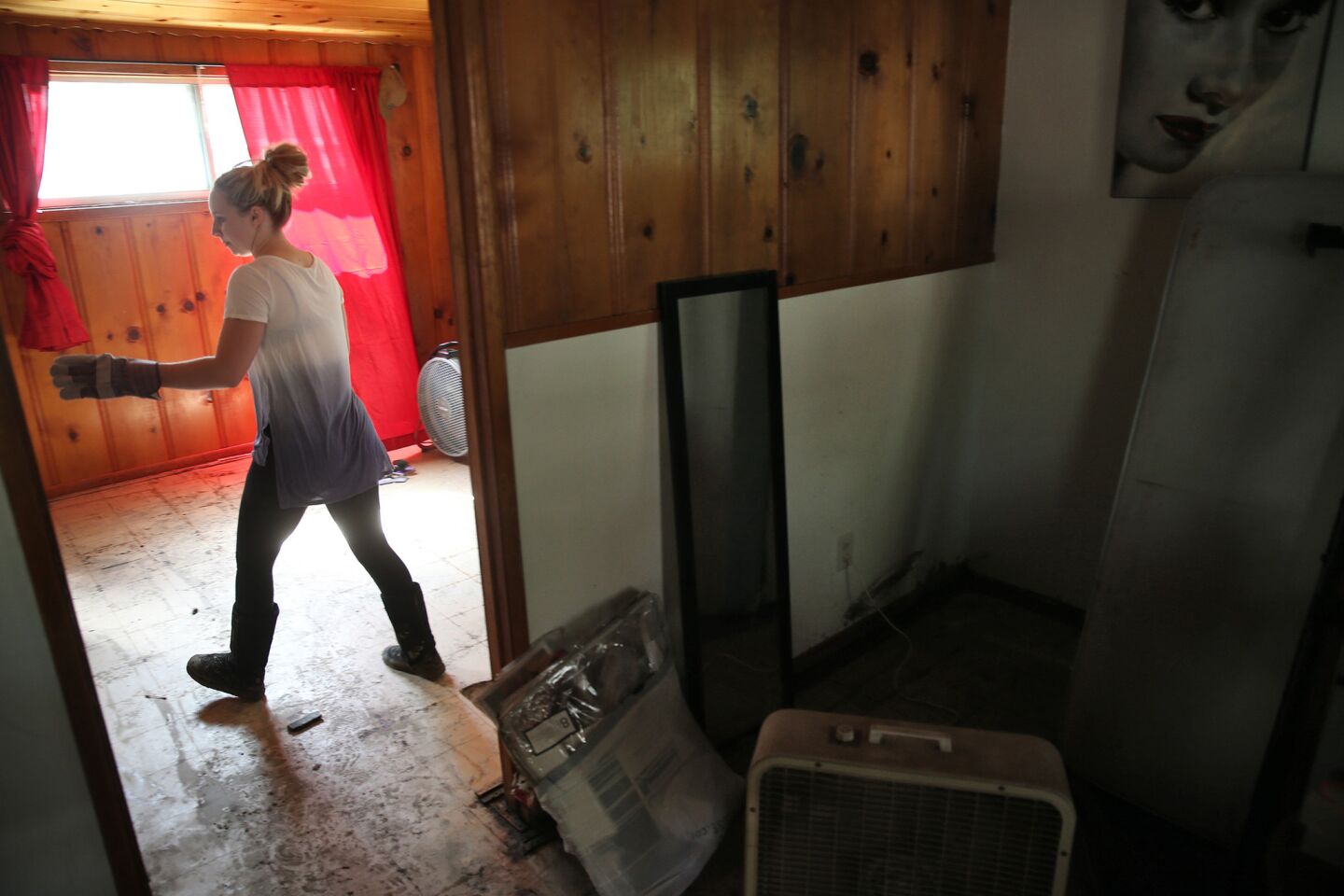 Addy Markley removes mud and debris from her Antelope Valley home.