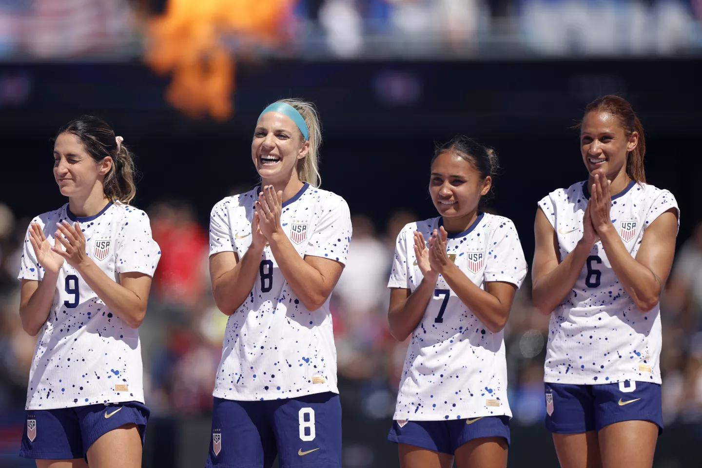 U.S. women’s national team players Savannah DeMelo, Julie Ertz, Alyssa Thompson and Lynn Williams acknowledge their fans after a win over Wales in an international friendly match in July.