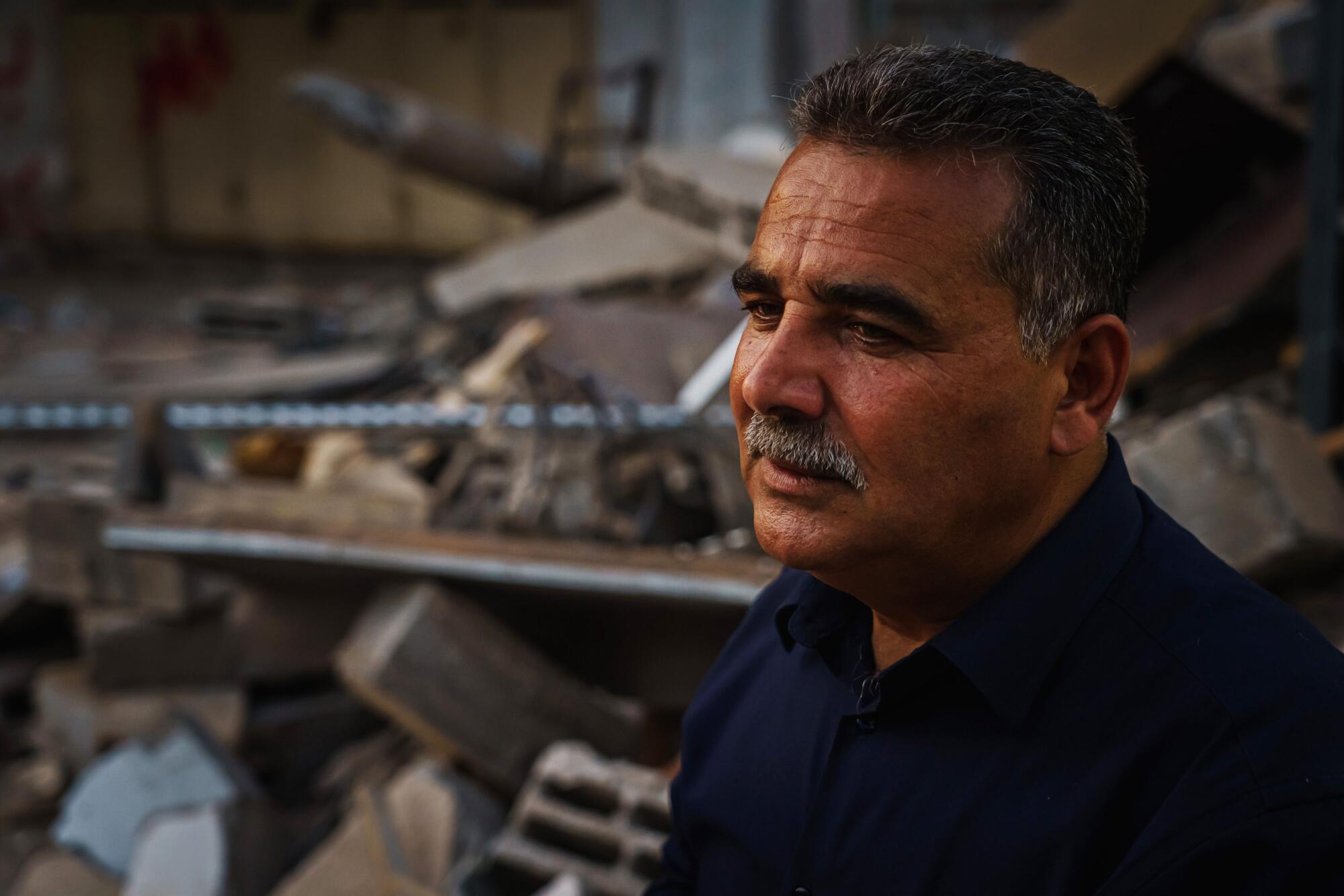 Samir Mansour before the ruins of his bookstore
