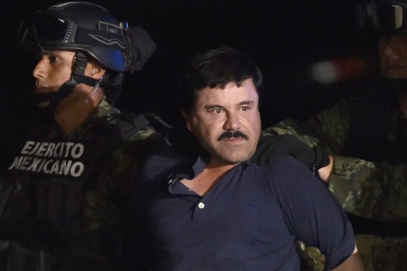 Drug kingpin Joaquin "El Chapo" Guzman is escorted to a helicopter at Mexico City's airport on January 8, 2016 following his recapture during an intense military operation in Los Mochis, in Sinaloa State. Mexican marines recaptured fugitive drug kingpin Joaquin "El Chapo" Guzman on Friday in the northwest of the country, six months after his spectacular prison break embarrassed authorities. AFP PHOTO / OMAR TORRES / AFP / OMAR TORRES (Photo credit should read OMAR TORRES/AFP via Getty Images)