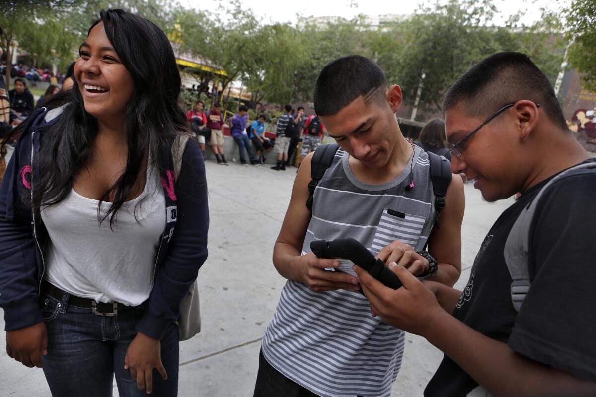 Bianca Gomez, left, Humberto Salazar and Doroteo Cruz were happy to receive iPads at Roosevelt High last year. Some Roosevelt students deleted security filters on the devices.