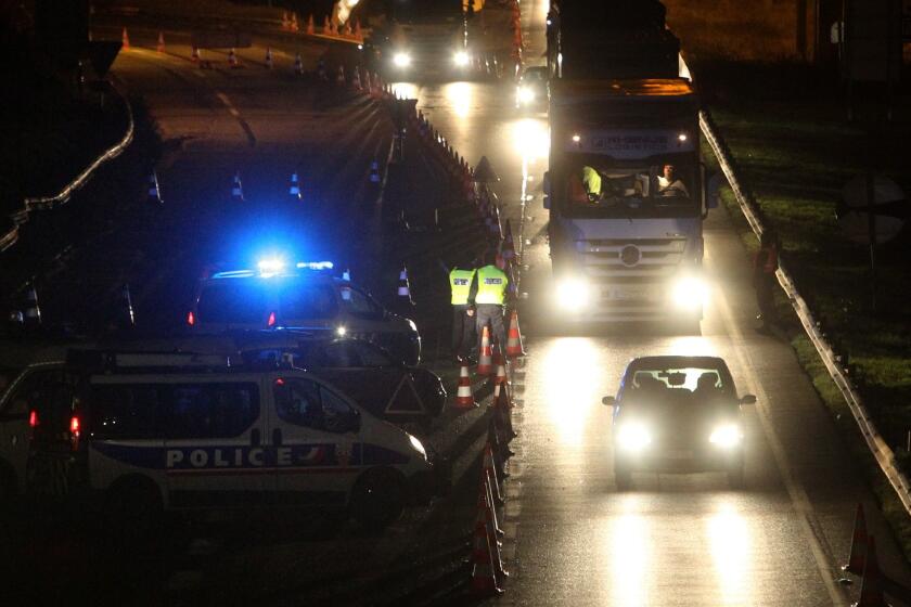 French police officers check vehicles on Tuesday at the border crossing to Belgium in Neuville-en-Ferrain as part of the hunt for fugitives wanted in connection with the Paris attacks.