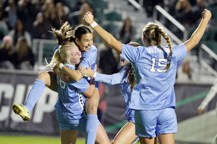North Carolina's Aleigh Gambone (16) is congratulated on her goal against Florida State by Tori Dellaperuta, as teammates gather during the first half of an NCAA women's soccer tournament semifinal in Cary, N.C., Friday, Dec. 2, 2022. (AP Photo/Karl B DeBlaker)