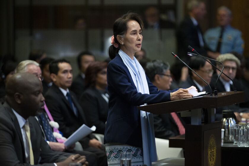 Myanmar's leader Aung San Suu Kyi addresses judges of the International Court of Justice as Gambia's Justice Minister Aboubacarr Tambadou, left, listens on the second day of three days of hearings in The Hague, Netherlands, Wednesday, Dec. 11, 2019. Aung San Suu Kyi will represent Myanmar in a case filed by Gambia at the ICJ, the United Nations' highest court, accusing Myanmar of genocide in its campaign against the Rohingya Muslim minority. (AP Photo/Peter Dejong)