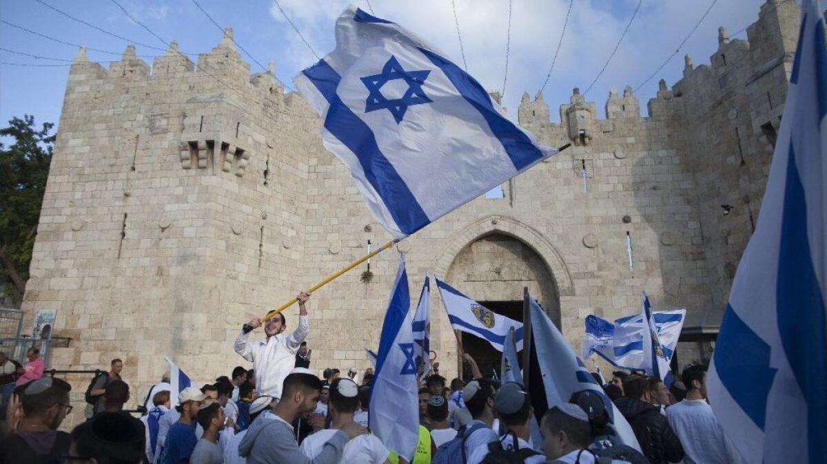 Israelis wave their national flag during a march outside Jerusalem's Damascus Gate on May 13, 2018.