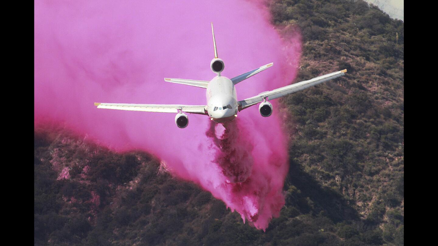 A 10 Tanker Air Carrier DC-10 drops an enormous amount of Phos-Chek onto the mountain hillside in the hills of the Angeles National Forest behind Duarte on Monday, June 20, 2016. Multiple aircraft circled the skies dropping water and Phos-Chek on hot spots and the hillside to prevent spreading into the community.