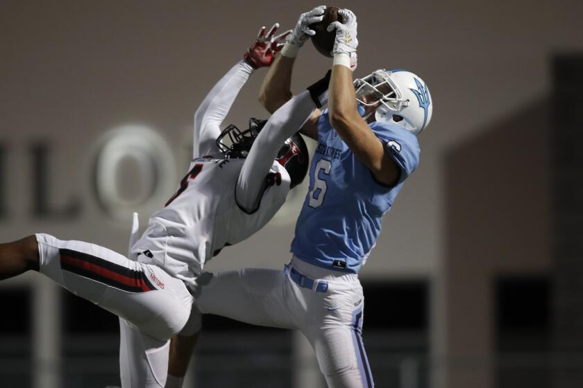 Corona del Mar High wide receiver John Humphreys, right, completes a touchdown reception against San Clemente's Nick Billoups during the first half in a nonleague game at Newport Harbor High on Thursday.