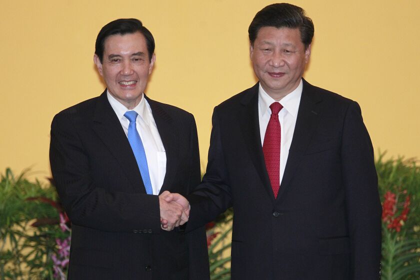 FILE - Then Taiwan's President Ma Ying-jeou, left, and China's President Xi Jinping shake hands at the Shangri-la Hotel on Nov. 7, 2015, in Singapore. Former Taiwan President Ma will visit China next week, in what a spokesman called an independent bid to ease tensions between the self-ruled island and the mainland. Ma, who's a member of the opposition Nationalist Party (Kuomingtang), will lead a delegation of academics and students as well as his former presidential staffers from March 27 to April 7, his office said Sunday.(AP Photo/Chiang Ying-ying)