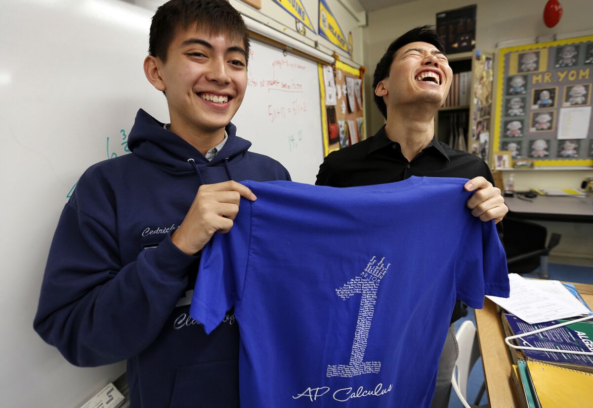 Cedrick Argueta, left, a senior at Lincoln High School in Lincoln Heights, and his math instructor, Anthony Yom, show off one of the AP Calculus T-shirts that students wore to their exam last spring.
