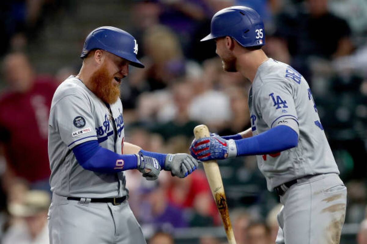 Dodgers' Justin Turner, left, celebrates with Cody Bellinger after hitting a two-run home run in the fourth inning against the Colorado Rockies.