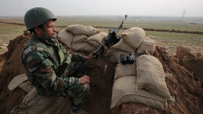 A Kurdish Peshmerga soldier watches the road between Mosul and Tal Afar in January.