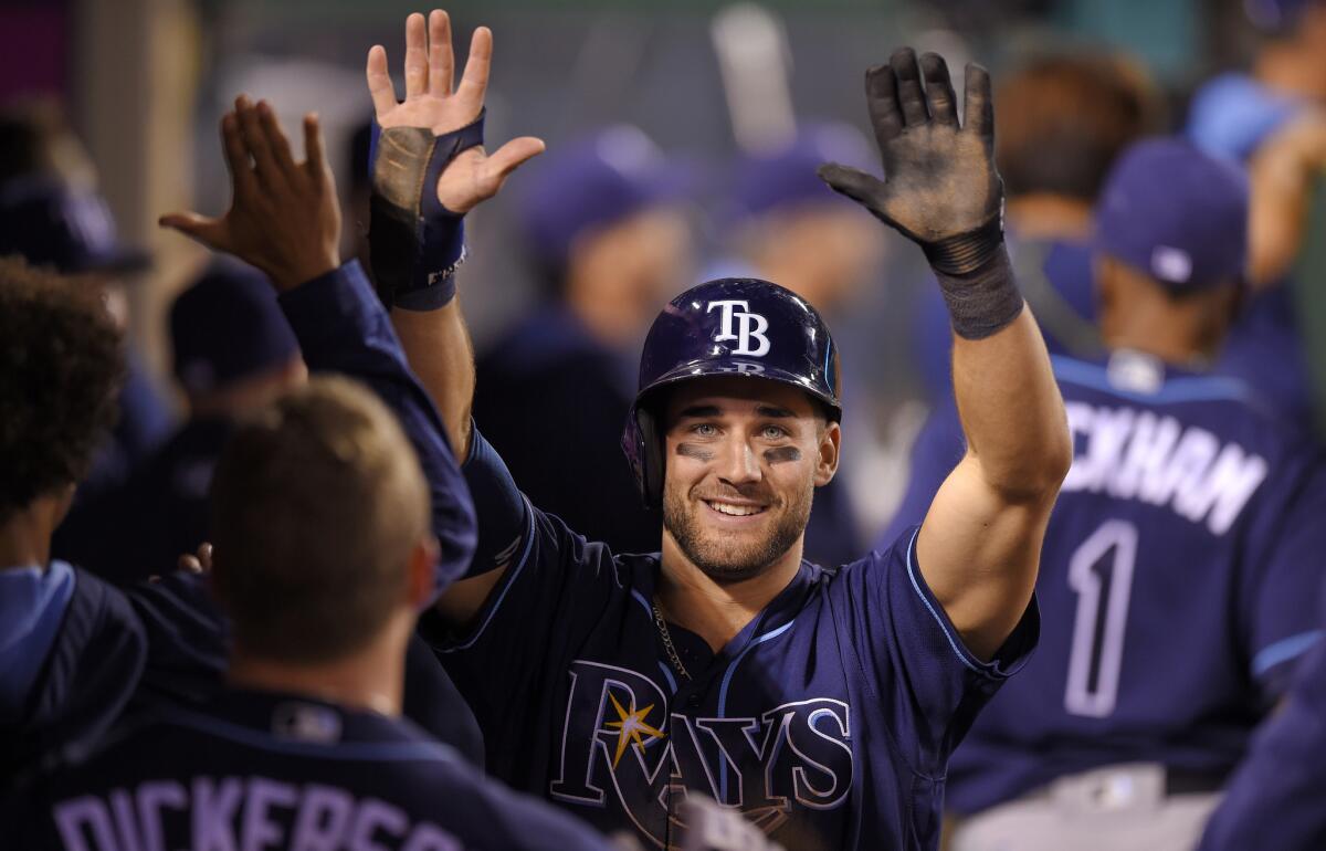 Tampa Bay's Kevin Kiermaier is congratulated by teammates after scoring against the Angels on a single by Logan Forsythe during the ninth inning Saturday.