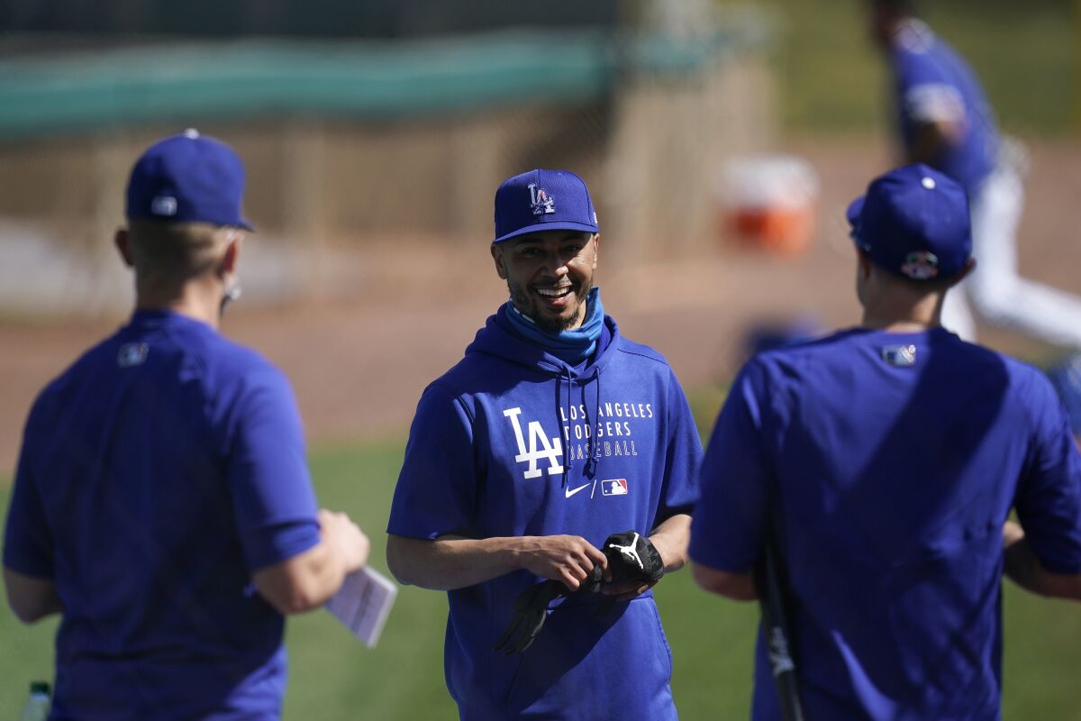 Dodgers hitting coach Brant Brown talks with Mookie Betts and A.J. Pollock.
