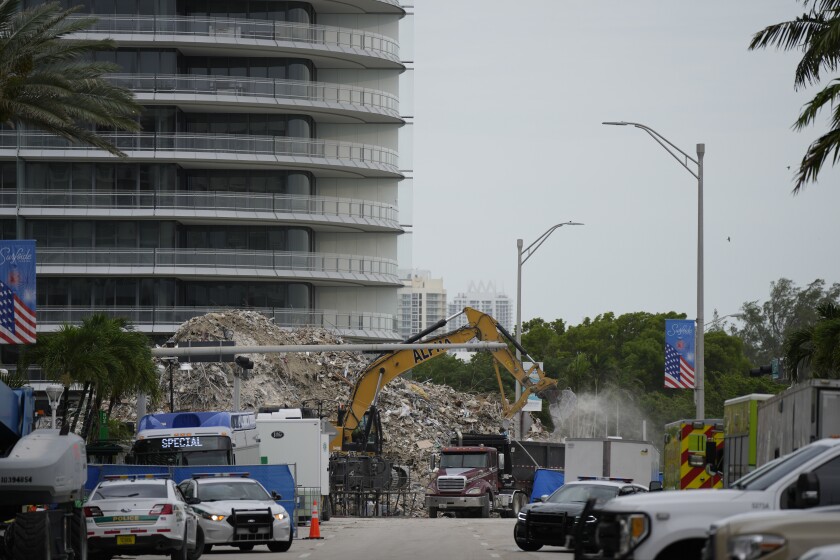 FILE - In this July 12, 2021 file photo, an excavator removes the rubble of the demolished section of the Champlain Towers South building, as recovery work continues at the site of the partially collapsed condo building, in Surfside, Fla. Another victim has been identified in the collapse of a 12-story Florida condominium. The Miami-Dade Police Department said in a news release Saturday, July 17, that Theresa Velasquez, 36, was a confirmed fatality in the June 24 collapse of the Champlain Towers South condo. (AP Photo/Rebecca Blackwell, File)