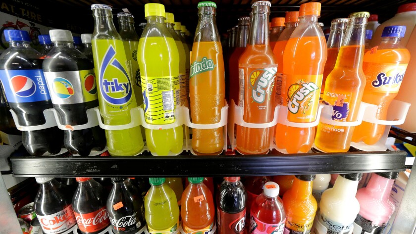 Soft drinks and soda bottles are displayed in a refrigerator at a market in San Francisco on Sept. 21. Next month, voters in San Francisco and Oakland will consider levying a penny per ounce tax on sugar laden drinks.